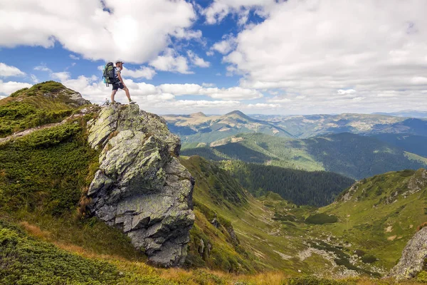 Caminante con una mochila de pie o piedra grande en verde rocosa mounta —  Fotos de Stock