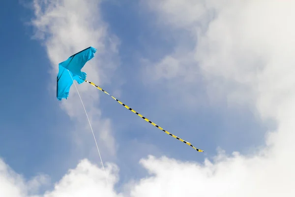 Воздушный змей летит в голубое небо в солнечный день — стоковое фото