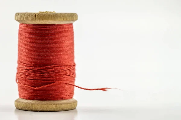 Reel or spool of red sewing thread isolated on white. Shallow de — Stock Photo, Image