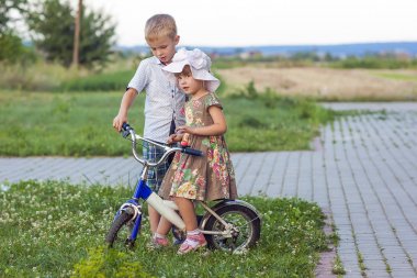 Erkek ve kız Bisiklet açık havada yaz güneşli bir günde oynamaya