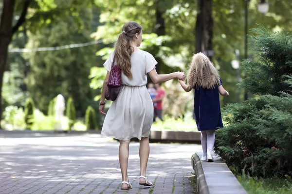 Rückansicht einer jungen Mutter, die mit ihrer kleinen Tochter in — Stockfoto