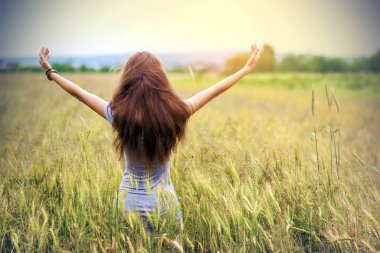 Buğday alan yükselterek uzun kahverengi saçlı ayakta olan kadın