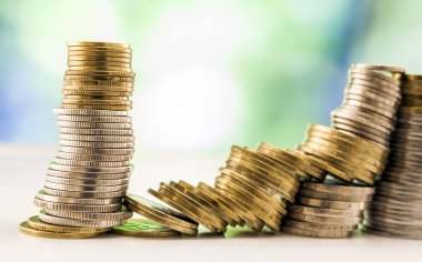 Paralar yığınlar yeşil ve mavi parlak bokeh backgro ile büyüyen