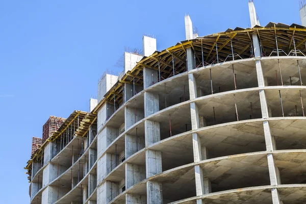 Modern building under construction against blue sky. Constructio