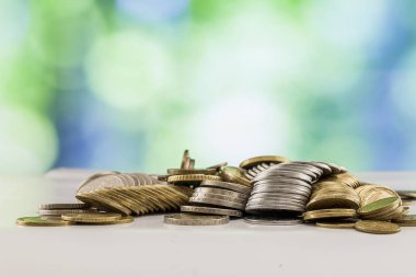 Paralar yığınlar yeşil ve mavi parlak bokeh backgro ile büyüyen