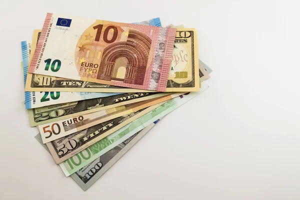 Banconote in dollari USA e banconote in euro sparse su sfondo bianco . — Foto Stock
