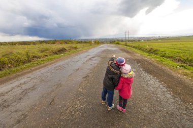 İki küçük çocuk erkek ve kız bir yolda yürürken