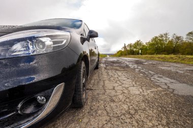 Kötü bir yol üzerinde modern bir otomobil yakın çekim resmi