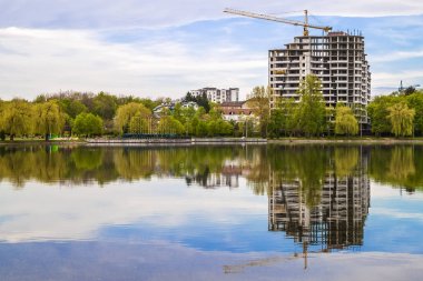 Yapım aşamasında bir göl kıyısında yeni modern gökdelen. 