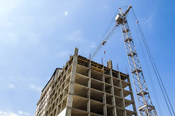 Modernes Gebäude im Bau vor blauem Himmel. Turmkran — Stockfoto