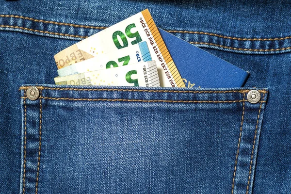 Billetes en euros y pasaporte de viaje en un bolsillo de azul jea —  Fotos de Stock