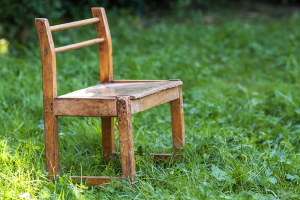 Pequeña silla vieja sobre hierba verde — Foto de Stock