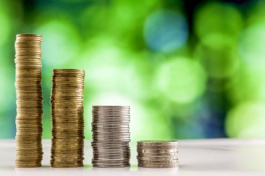 Paralar yığınlar yeşil ve mavi parlak bokeh backgro ile büyüyen