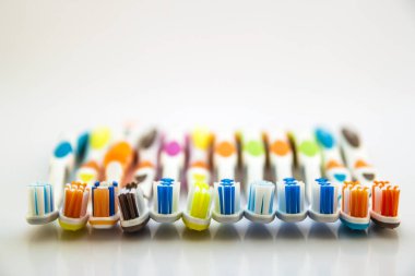 Bardak temiz toile üzerinde çok renkli diş fırçaları kümesini kapatın