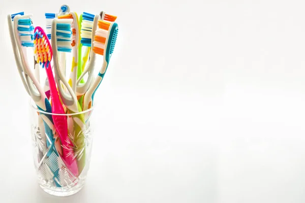 Close up shot of set of multicolored toothbrushes in glass on cl — Stock Photo, Image