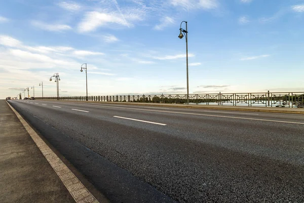 Estrada de asfalto vazia em uma ponte sobre o rio — Fotografia de Stock