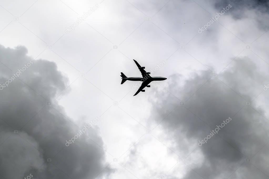 Stormy Clouds in Dark Sky and a Passenger Plane. Jet Aircraft on