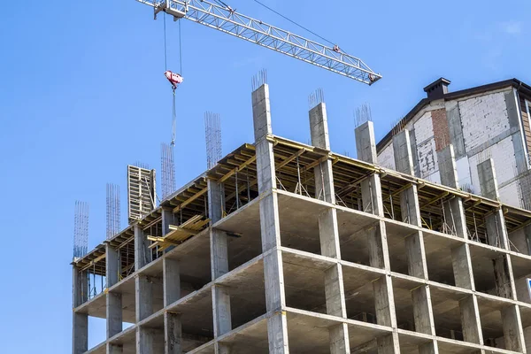 Modern gebouw in aanbouw tegen blauwe hemel. Toren kraan — Stockfoto