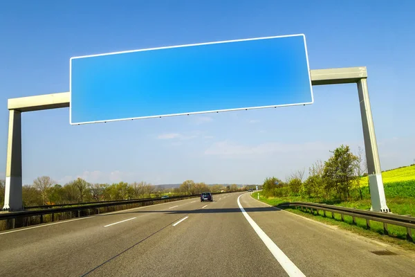 Blank blue freeway sign over the road on sunny day — Stock Photo, Image