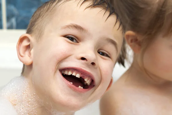 Счастливый смеющийся мальчик принимает ванну. Молочные зубы отсутствуют — стоковое фото