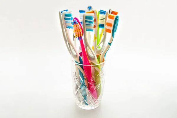 Close up shot of set of multicolored toothbrushes in glass on cl — Stock Photo, Image