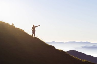 Adam dağ tepe üzerinde. Duygusal sahne. Backpac ile genç adam