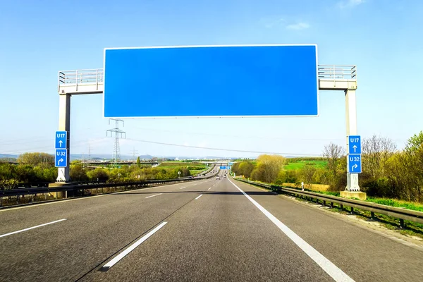 Blank blue freeway sign over the road on sunny day — Stock Photo, Image