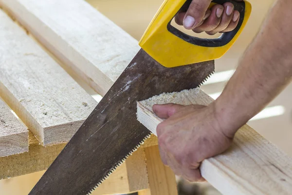 Mano de carpintero con sierra para cortar tablas de madera — Foto de Stock