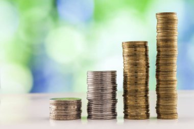 Paralar yığınlar yeşil ve mavi parlak bokeh backgro ile büyüyen