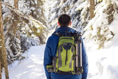 Kış ormanda hiking sırt çantası ile genç adam