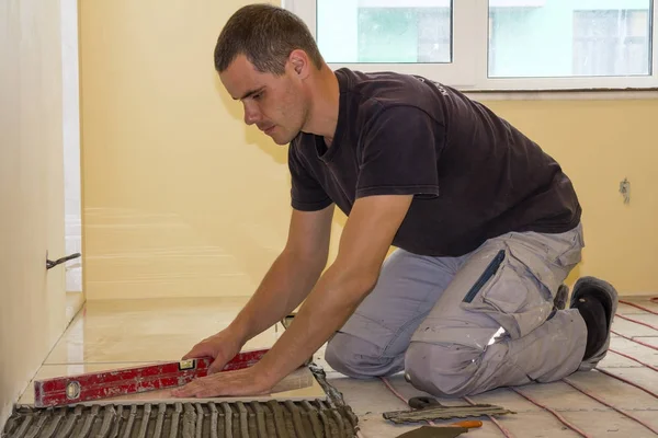 Pracownik Instalowanie płytki podłogowe. Płytki ceramiczne i narzędzia dla glazurnik — Zdjęcie stockowe