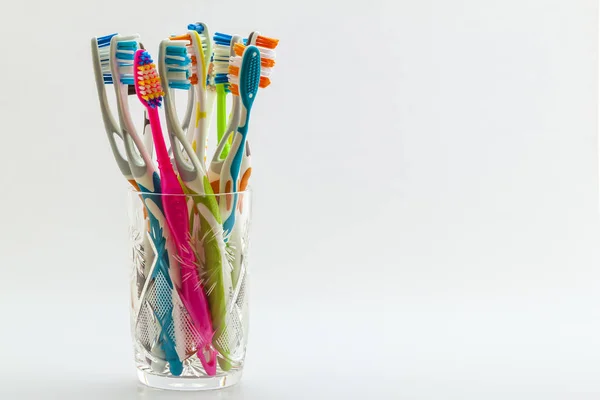 Close up shot of set of multicolored toothbrushes in glass on cl — Stock Photo, Image