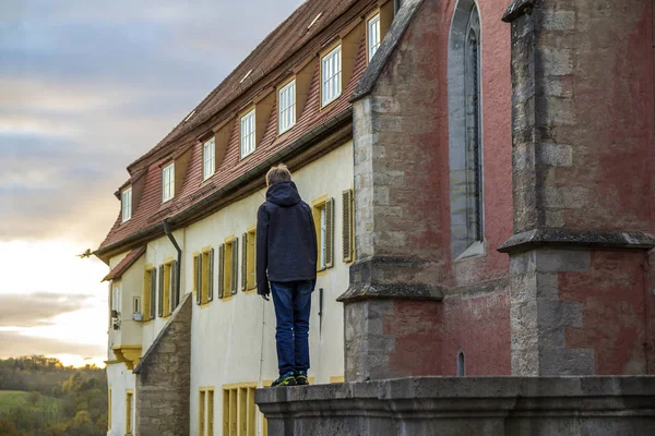 Mały chłopiec stoi w starym mieście, ciesząc się widokiem — Zdjęcie stockowe