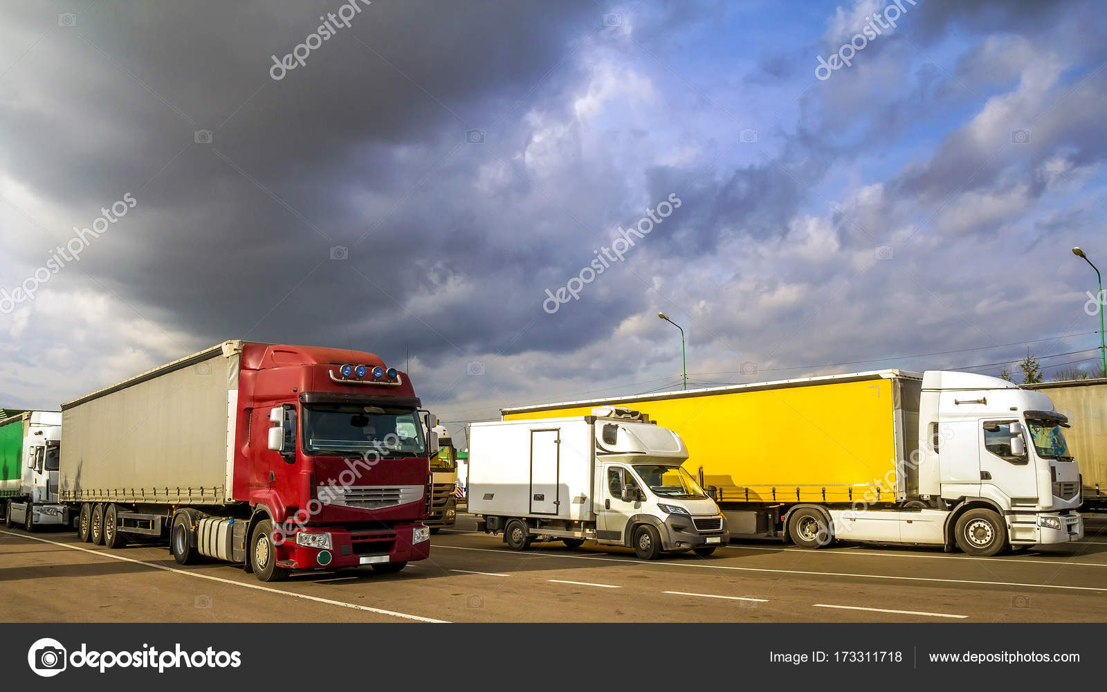 Colorful modern big semitrucks and trailers of different makes Stock Photo by ©bilanol.i.ua