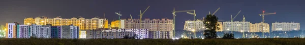 Panorama night view of many building cranes at construction site — Stock Photo, Image