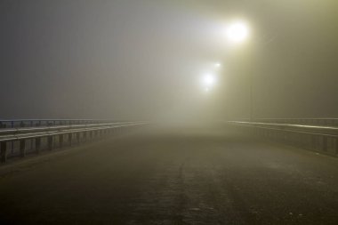 Geceleri boş yol üzerinde kalın sis