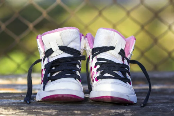 Par de zapatos blancos para niños sobre fondo natural — Foto de Stock