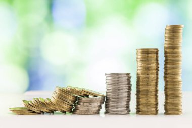 Paralar yığınlar yeşil ve mavi parlak bokeh backgro ile büyüyen