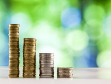 Paralar yığınlar yeşil ve mavi parlak bokeh backgro ile büyüyen