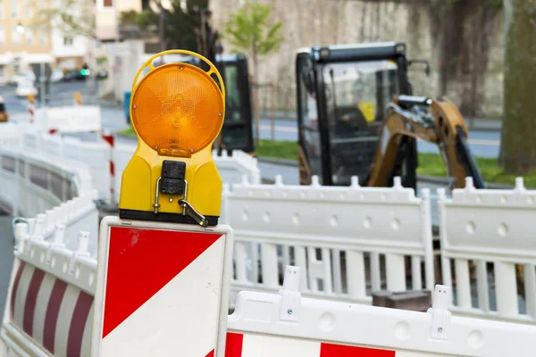 Orangefarbene Baustellenampel auf Barrikade. Nachteile im Straßenverkehr — Stockfoto