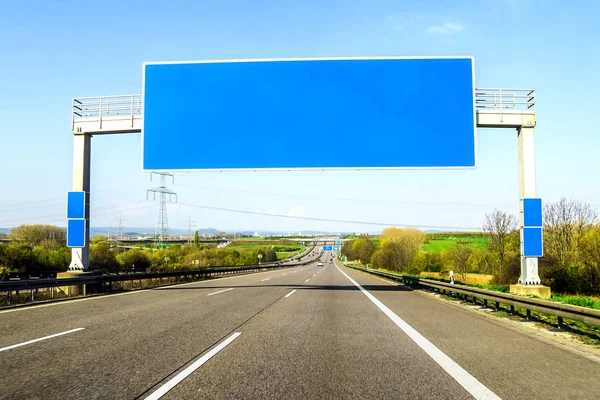 Lege blauwe freeway teken over de weg op zonnige dag — Stockfoto