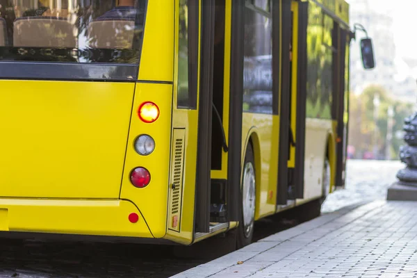 Ônibus urbano amarelo moderno com portas abertas na estação de ônibus — Fotografia de Stock