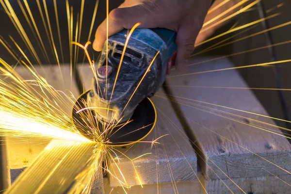 Primer plano de las manos de los trabajadores cortando metal con amoladora. Chispas mientras — Foto de Stock