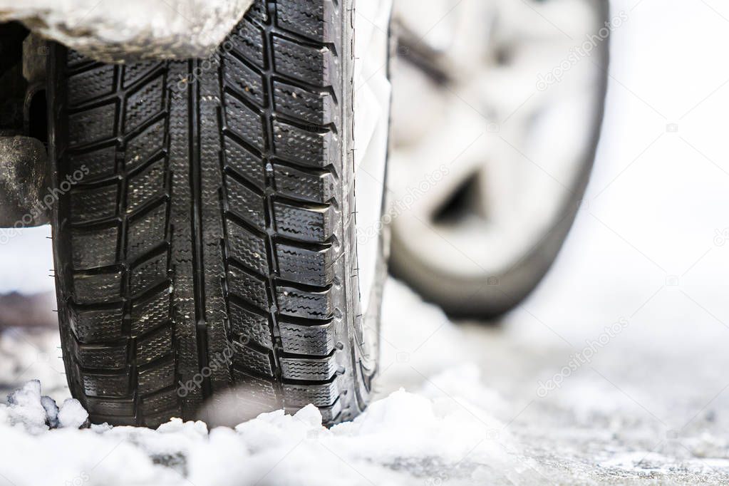 Close-up of car wheel in winter tire on snowy road