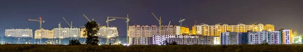 Panorama night view of many building cranes at construction site — Stock Photo, Image