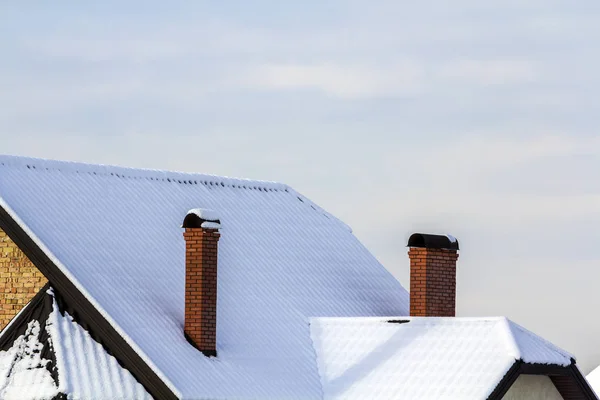 Taket på huset med tegel skorstenar täckt med snö på vintern — Stockfoto