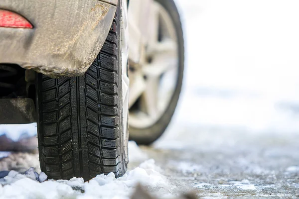 Karlı yolda araba tekerlek içinde kış lastiği Close-Up