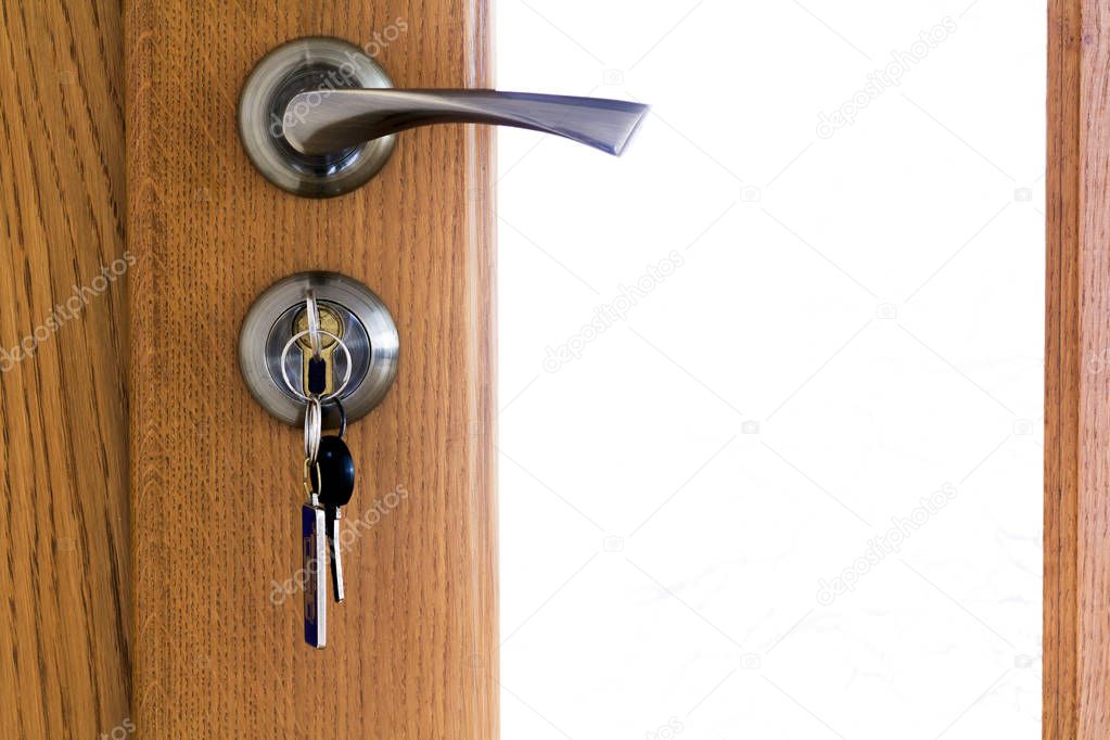 Modern, contemporary satin metal handle and a key in lock on a w