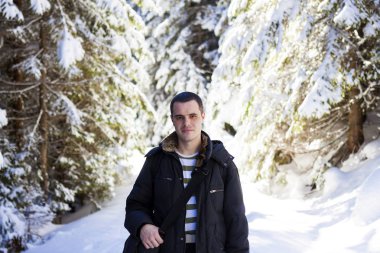 Adam turist hiker karda kış çam ormanı kaplı