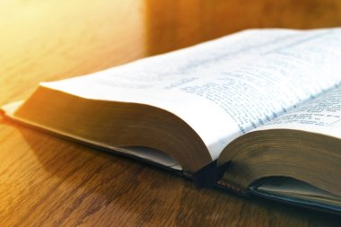 Sarı ahşap arka plan üzerine açık kitap İncil'de